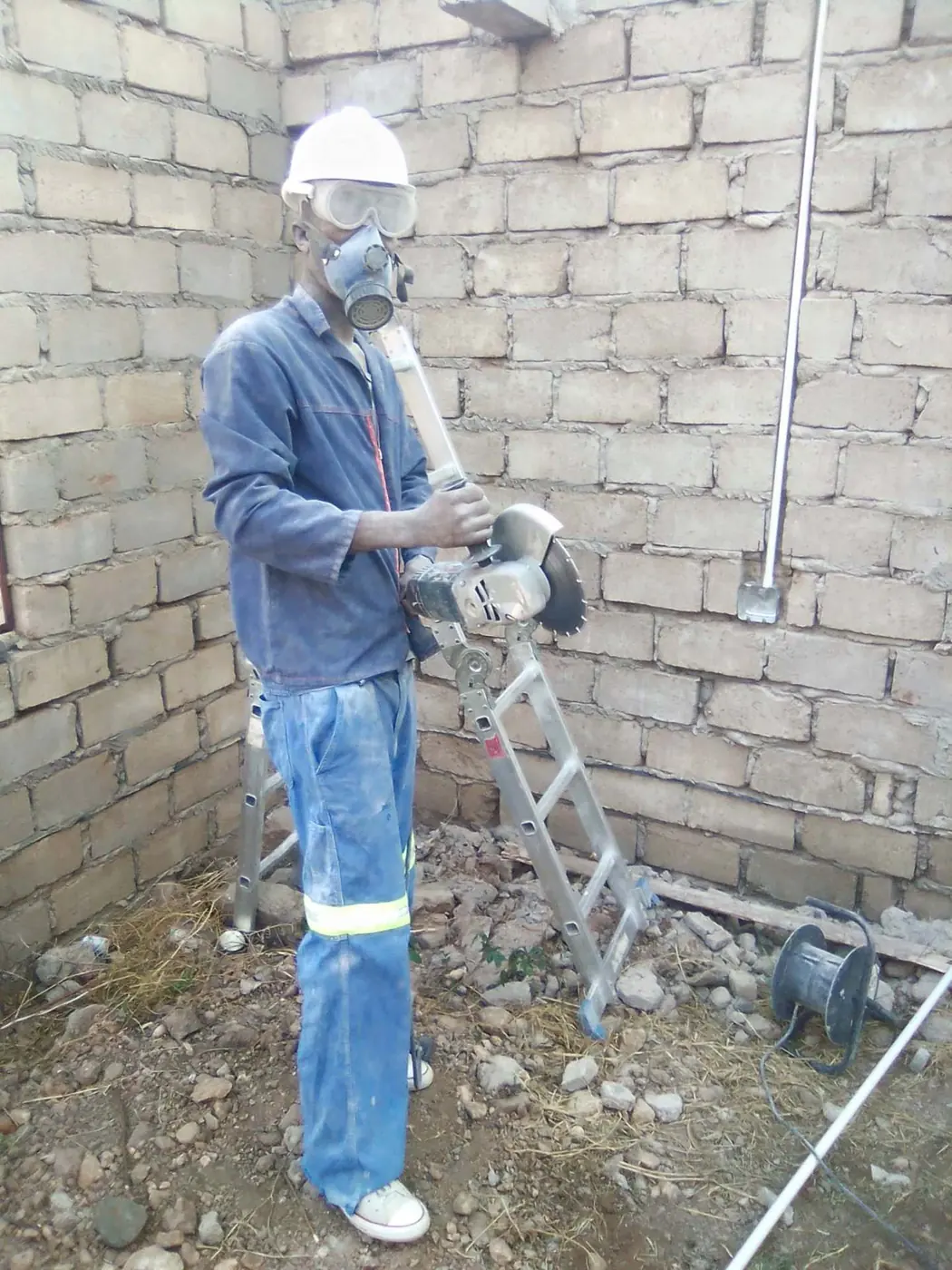 Worker in protective gear chasing walls for conduit